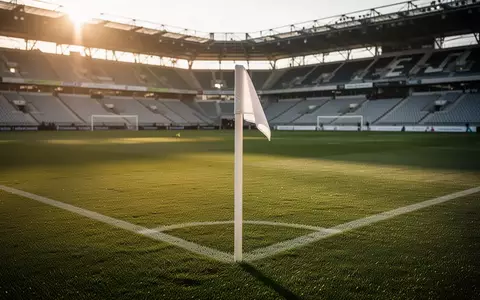 Ein leeres Fußballstadion in Linz bei Sonnenuntergang mit Fokus auf das gepflegte Spielfeld und die Eckfahne. - Foto: über boerse-global.de