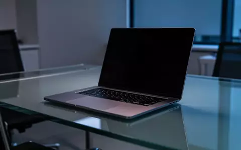 Ein moderner, dunkel beleuchteter Büroarbeitsplatz mit einem Laptop auf einem minimalistischen Schreibtisch. - Foto: über boerse-global.de