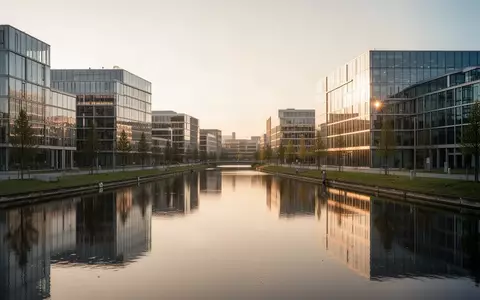 Moderne Büro- und Industriegebäude an einem Kanal bei Sonnenuntergang als Symbol für den Wirtschaftsstandort Deutschland. - Foto: über boerse-global.de