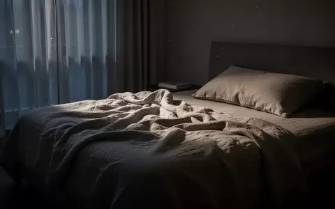 Ein ungemachtes Bett in einem sanft beleuchteten, ruhigen Schlafzimmer bei Dämmerlicht. - Foto: über boerse-global.de
