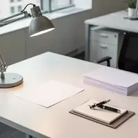 Ein leerer, aufgeräumter Schreibtisch mit Schreibutensilien und natürlichem Lichteinfall in einem modernen Büro. - Foto: über boerse-global.de