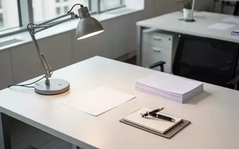 Ein leerer, aufgeräumter Schreibtisch mit Schreibutensilien und natürlichem Lichteinfall in einem modernen Büro. - Foto: über boerse-global.de