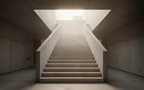 Eine minimalistische Steintreppe führt in einem modernen Gebäude nach oben in helles, diffuses Tageslicht. - Foto: über boerse-global.de