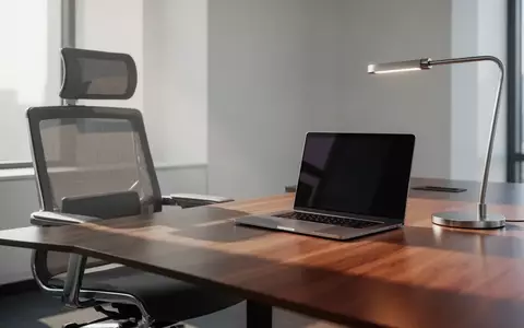 Ein minimalistischer, moderner Büroarbeitsplatz mit einem leeren Schreibtisch und einem ausgeschalteten Laptop in einer professionellen Umgebung. - Foto: über boerse-global.de