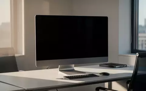 Ein moderner Büroarbeitsplatz mit einem ausgeschalteten, schwarzen Computerbildschirm in einem minimalistischen Raum. - Foto: über boerse-global.de