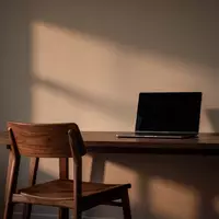 Ein leerer Schreibtisch mit einem ausgeschalteten Laptop in einer ruhigen, schattigen Büroumgebung. - Foto: über boerse-global.de
