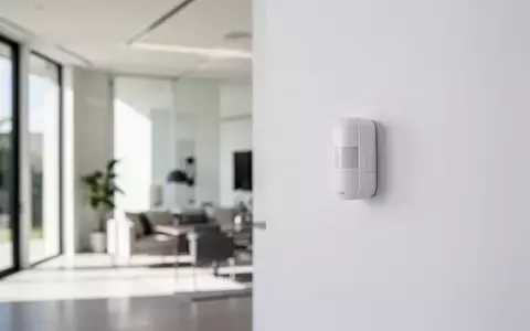 Modernes, minimalistisches Wohninterieur mit einem unauffälligen Sicherheitssensor an einer weißen Wand. - Foto: über boerse-global.de