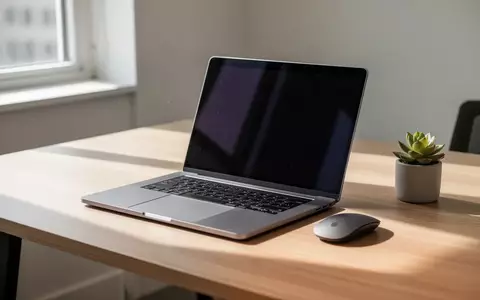 Ein minimalistischer Arbeitsplatz mit einem Laptop mit dunklem Bildschirm auf einem hellen Holztisch bei Tageslicht. - Foto: über boerse-global.de