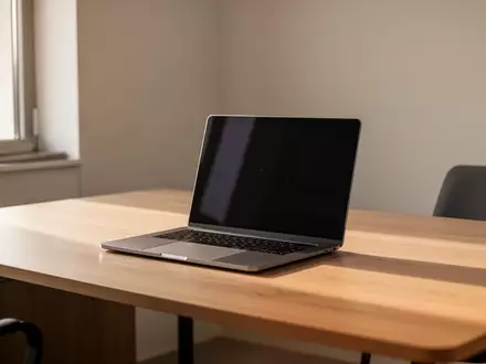 Ein minimalistischer Büro-Arbeitsplatz mit einem modernen Laptop mit schwarzem Bildschirm auf einem Holztisch. - Foto: über boerse-global.de