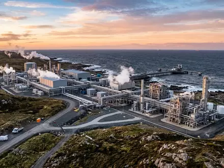 Moderne Wasserstoff-Produktionsanlage an einer Küstenlandschaft bei Sonnenaufgang. - Foto: über boerse-global.de