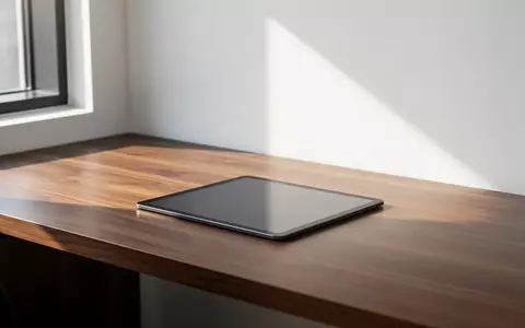 Ein minimalistischer Büroarbeitsplatz mit einem leeren dunklen Tablet auf einem Holztisch bei natürlichem Tageslicht. - Foto: über boerse-global.de