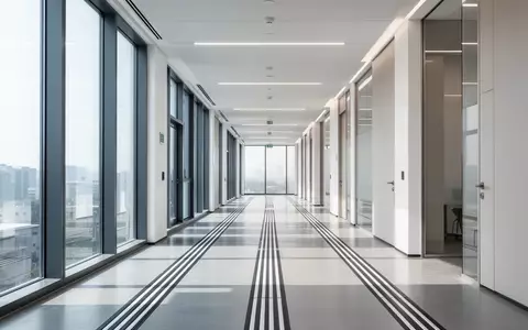 Ein heller, moderner Büroflur mit taktilen Bodenleitsystemen für barrierefreien Zugang bei natürlichem Tageslicht. - Foto: über boerse-global.de