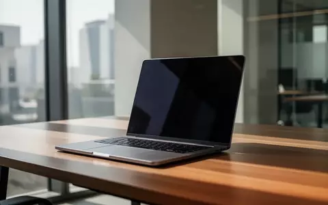 Ein moderner, minimalistischer Arbeitsplatz mit einem Laptop auf einem Holztisch in einem hellen Bürogebäude. - Foto: über boerse-global.de