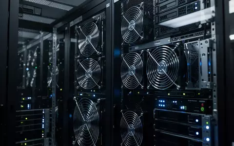 Dunkler Serverraum mit Reihen von Rack-Servern und blinkenden Statusleuchten in einer professionellen IT-Infrastruktur. - Foto: über boerse-global.de