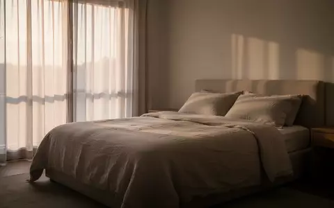 Ein minimalistisch eingerichtetes, ruhiges Schlafzimmer bei sanftem Morgenlicht, das eine Atmosphäre der Erholung vermittelt. - Foto: über boerse-global.de