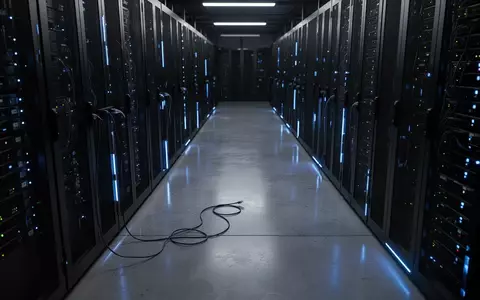 Dunkler Serverraum mit beleuchteten Server-Racks und einem herabhängenden Netzwerkkabel in einer industriellen Umgebung. - Foto: über boerse-global.de