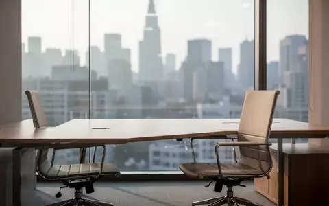 Ein leerer, moderner Büroarbeitsplatz mit einem Schreibtisch und einem Bürostuhl vor einem großen Fenster. - Foto: über boerse-global.de