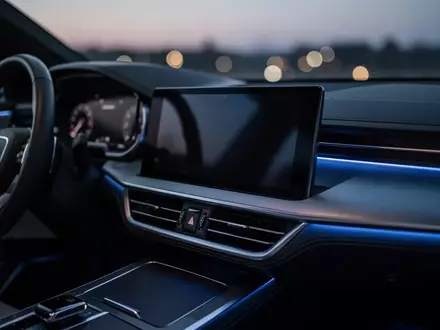 Ein modernes, dunkles Infotainment-Display in einem Fahrzeuginterieur bei Dämmerung. - Foto: über boerse-global.de