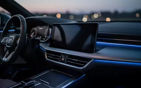 Ein modernes, dunkles Infotainment-Display in einem Fahrzeuginterieur bei Dämmerung. - Foto: über boerse-global.de