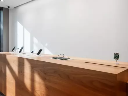 Ein minimalistischer, leerer Kundenservice-Tresen in einem modernen Elektronikgeschäft bei hellem Tageslicht. - Foto: über boerse-global.de