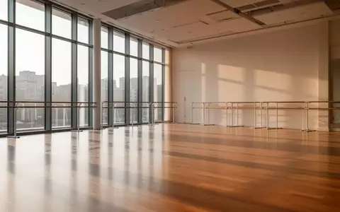 Ein heller, leerer Tanzsaal mit Parkettboden und großen Fenstern, durch die natürliches Tageslicht fällt. - Foto: über boerse-global.de