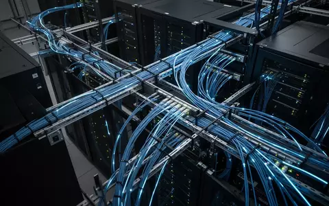 Moderne Server-Infrastruktur mit blau leuchtenden Glasfaserkabeln in einem professionellen Rechenzentrum. - Foto: über boerse-global.de