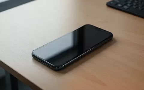 Ein modernes Smartphone liegt auf einem Schreibtisch, der Bildschirm ist dunkel und spiegelt das Umgebungslicht wider. - Foto: über boerse-global.de