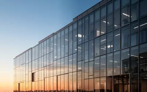 Moderne Glasfassade eines Bürogebäudes bei Sonnenuntergang als Symbol für Konzernstrukturen. - Foto: über boerse-global.de