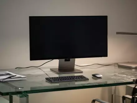 Ein minimalistischer Arbeitsplatz mit einem ausgeschalteten Monitor auf einem modernen Schreibtisch. - Foto: über boerse-global.de