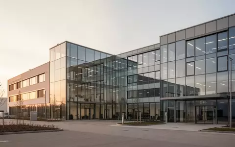 Modernes Gewerbeimmobilien-Gebäude bei Sonnenuntergang als Symbol für die Unternehmensintegration der VIB Vermögen AG. - Foto: über boerse-global.de