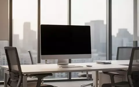 Ein moderner, unbesetzter Arbeitsplatz mit einem ausgeschalteten Monitor in einem hellen Bürogebäude. - Foto: über boerse-global.de