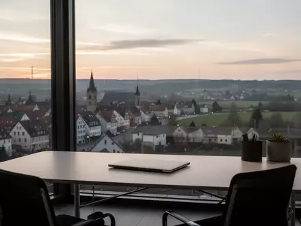 Ein minimalistischer Homeoffice-Arbeitsplatz vor einem Fenster mit Blick auf eine Grenzregion bei Tagesanbruch. - Foto: über boerse-global.de