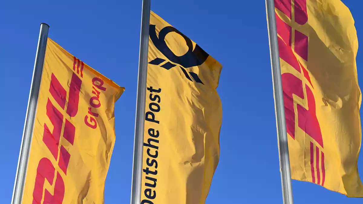 Eine Deutsche-Post-Fahne an der Konzernzentrale umrahmt von DHL-Fahnen. So soll es bleiben. - Bild: Wolf von Dewitz/dpa