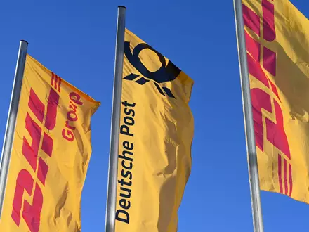 Eine Deutsche-Post-Fahne an der Konzernzentrale umrahmt von DHL-Fahnen. So soll es bleiben. - Foto: Wolf von Dewitz/dpa