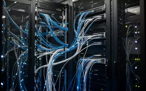 Modernes Rechenzentrum mit leuchtenden Glasfaserkabeln in dunklen Serverracks. - Foto: über boerse-global.de