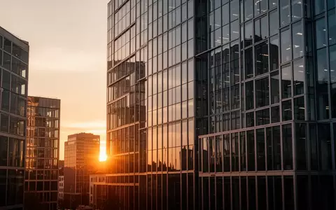 Moderne Glasfassade eines Bankgebäudes im Finanzviertel bei Sonnenuntergang. - Foto: über boerse-global.de