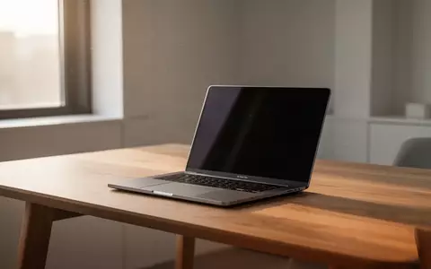 Ein geschlossener Laptop auf einem minimalistischen Holztisch in einem hellen, modernen Büro. - Foto: über boerse-global.de