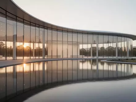 Die moderne Glasfassade des Apple Park Hauptquartiers bei Sonnenuntergang. - Foto: über boerse-global.de