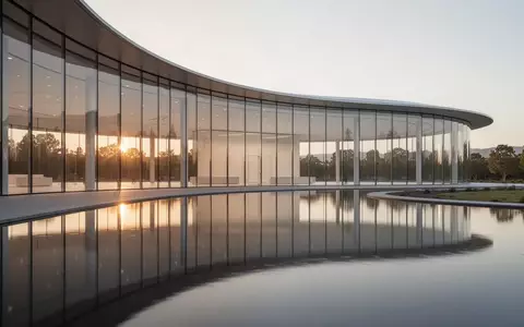 Die moderne Glasfassade des Apple Park Hauptquartiers bei Sonnenuntergang. - Foto: über boerse-global.de