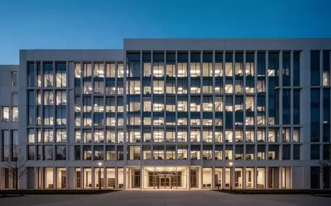 Modernes Verwaltungsgebäude in der Dämmerung mit beleuchteten Fenstern. - Foto: über boerse-global.de