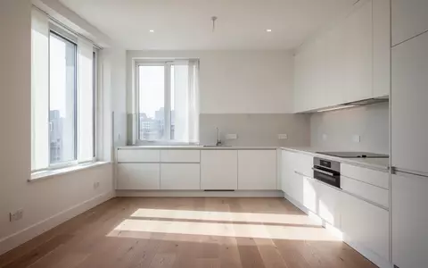 Leere, lichtdurchflutete Küche in einer modernen Wohnung mit großen Fenstern und Holzboden. - Foto: über boerse-global.de