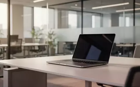 Ein minimalistischer, moderner Arbeitsplatz in einem hellen Büro mit einem Laptop bei ausgeschaltetem Bildschirm. - Foto: über boerse-global.de