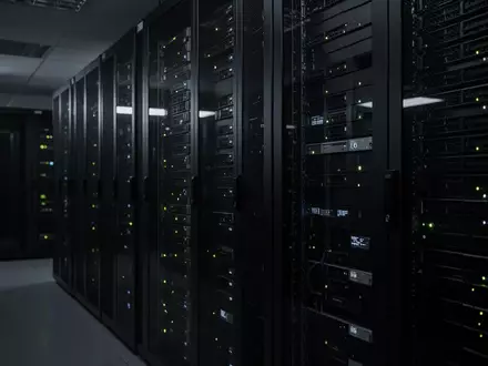 Ein dunkler Serverraum mit blinkenden Kontrollleuchten in einem modernen Rechenzentrum. - Foto: über boerse-global.de