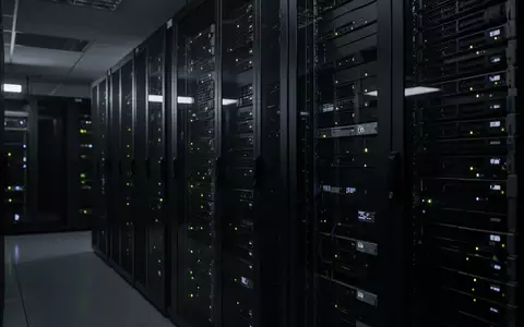 Ein dunkler Serverraum mit blinkenden Kontrollleuchten in einem modernen Rechenzentrum. - Foto: über boerse-global.de