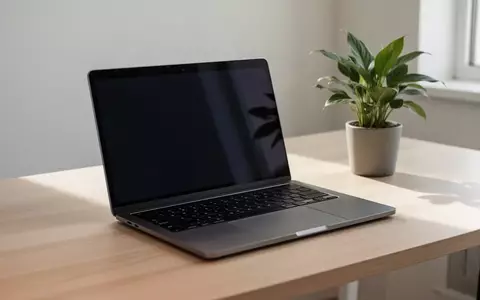 Ein minimalistischer Arbeitsplatz mit einem modernen Laptop mit dunklem Bildschirm auf einem Holztisch. - Foto: über boerse-global.de