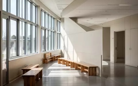 Ein heller, leerer Flur in einem modernen Schulgebäude mit großen Fenstern und einfallendem Tageslicht. - Foto: über boerse-global.de