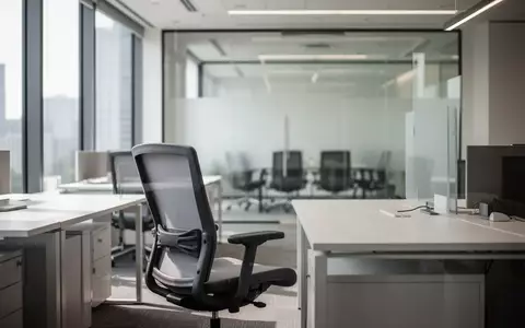 Ein leerer, modern eingerichteter Büroarbeitsplatz mit Schreibtisch und ergonomischem Stuhl in einem hellen Bürogebäude. - Foto: über boerse-global.de