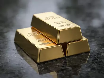 Mehrere Goldbarren auf einer dunklen, reflektierenden Oberfläche bei gedimmtem Licht. - Foto: über boerse-global.de