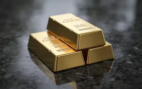 Mehrere Goldbarren auf einer dunklen, reflektierenden Oberfläche bei gedimmtem Licht. - Foto: über boerse-global.de