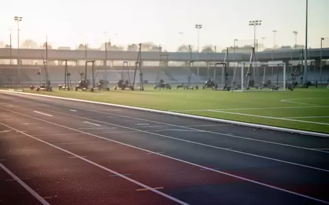 Leere Sportanlage mit Laufbahn und Rasenplatz im sanften Morgenlicht. - Foto: über boerse-global.de